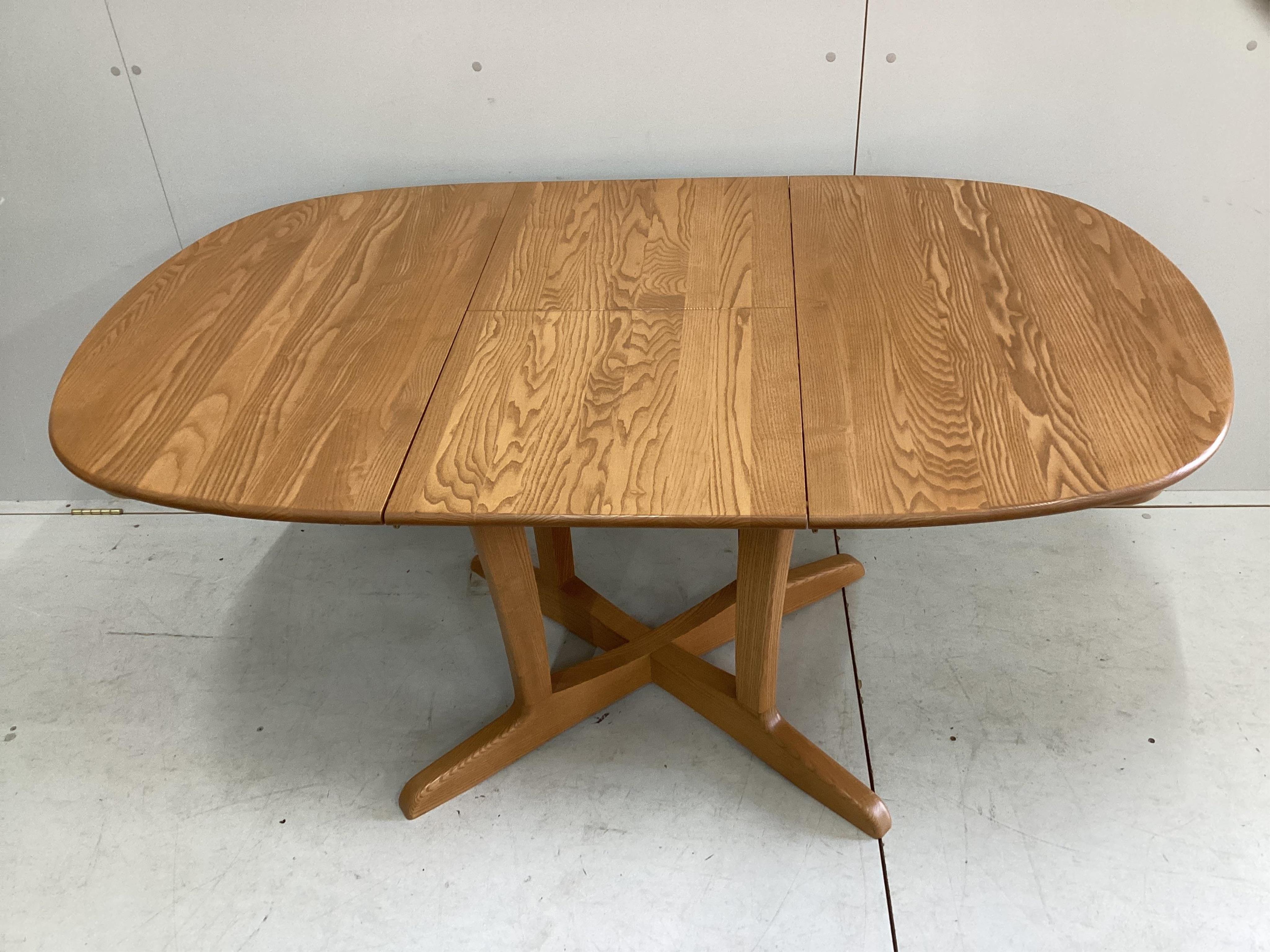 A modern Ercol elm extending dining table and six chairs, table 150cm extended, depth 89cm, height 73cm. Condition - good